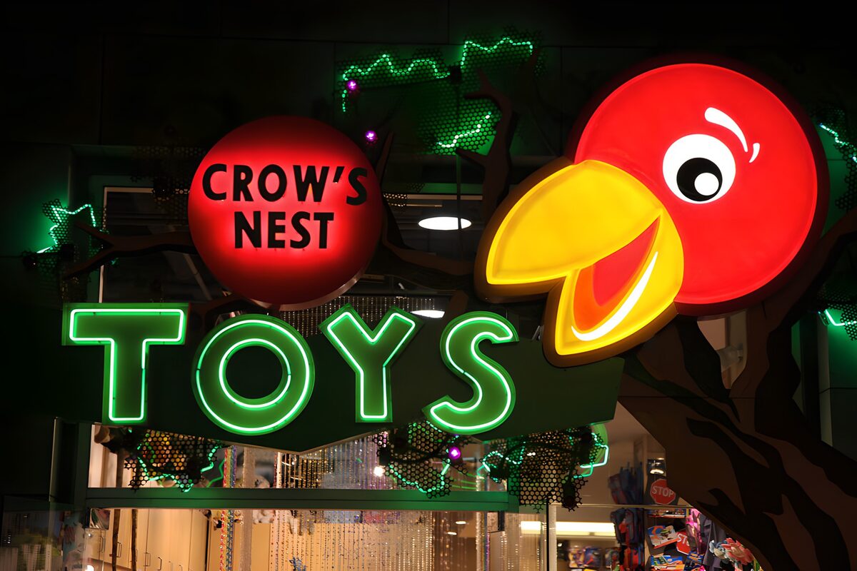 Roter Vogel über leuchtendem TOYS-Schriftzug
