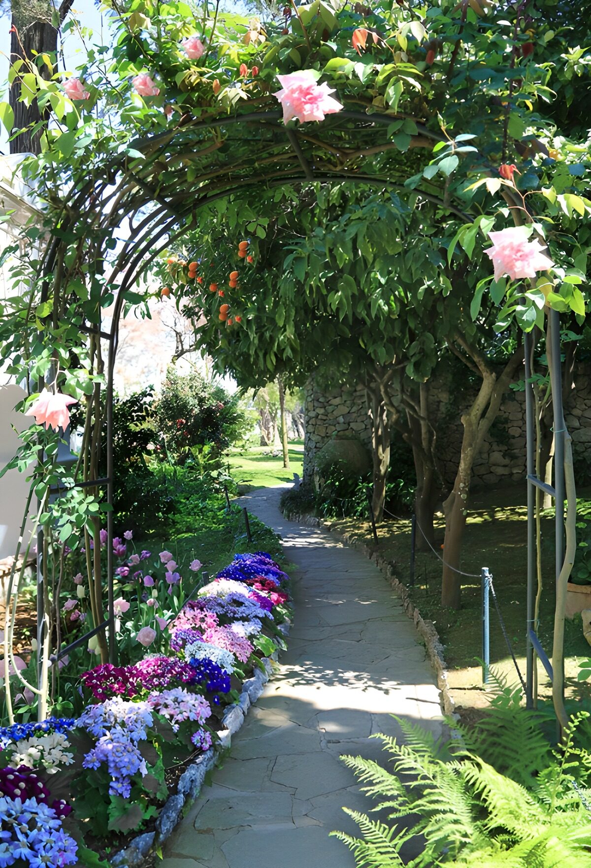 Steinweg unter einem rosa Blütenbogen