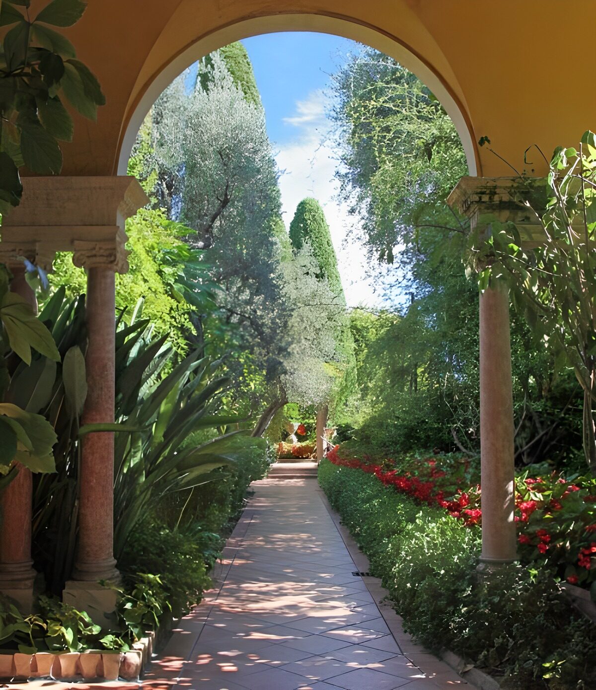 Gartenweg mit Säulen und ockerfarbenem Bogen