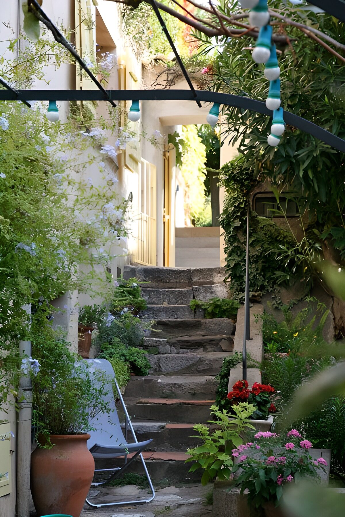 Steintreppe zwischen Blumen und Hauswänden
