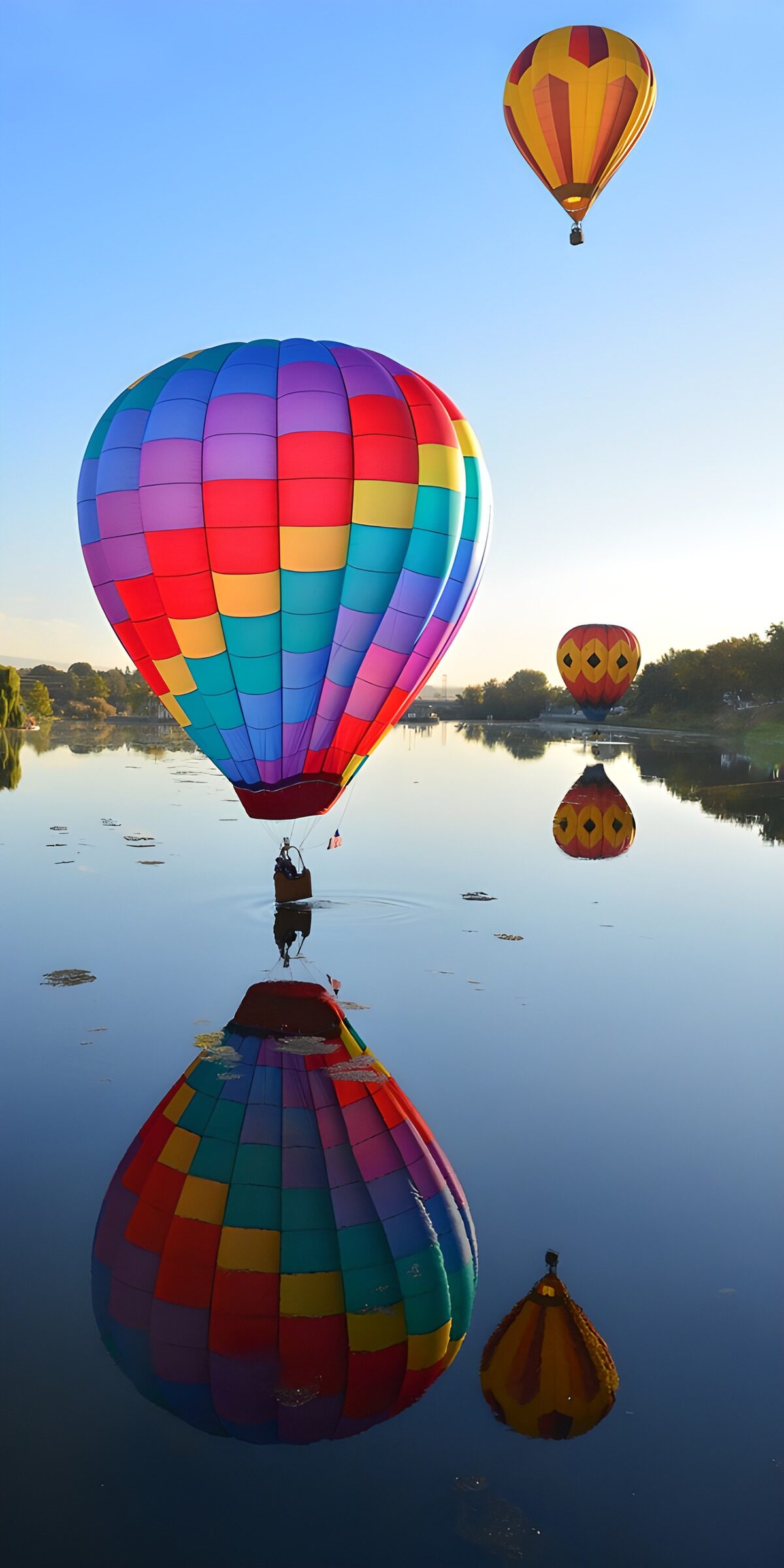 Drei Heißluftballons über stillem Wasser