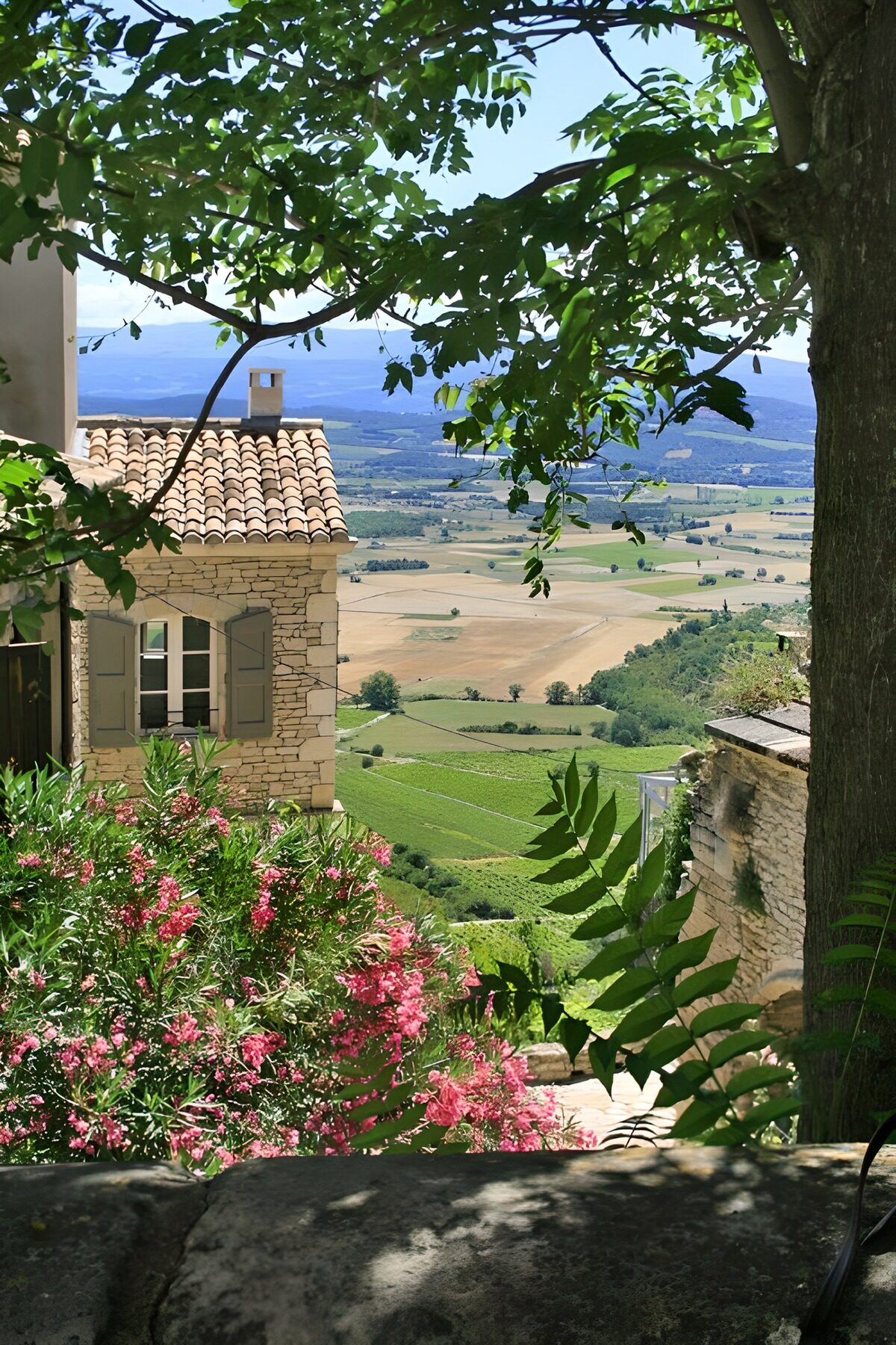 Steinhaus mit blühendem Garten und Talblick