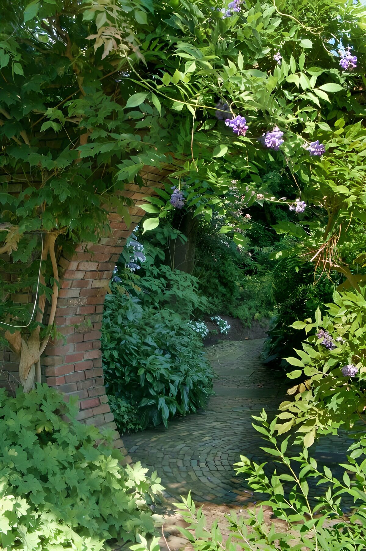Bewachsener Ziegelbogen im stillen Garten