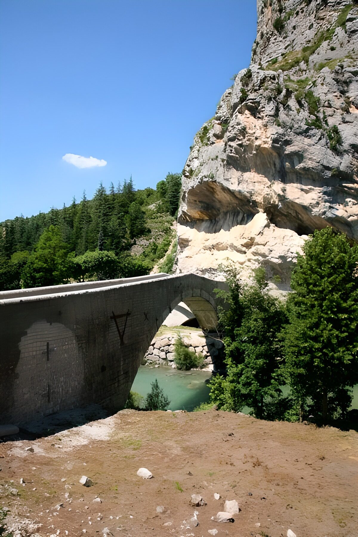 Bogenbrücke am Fluss im Sonnenlicht