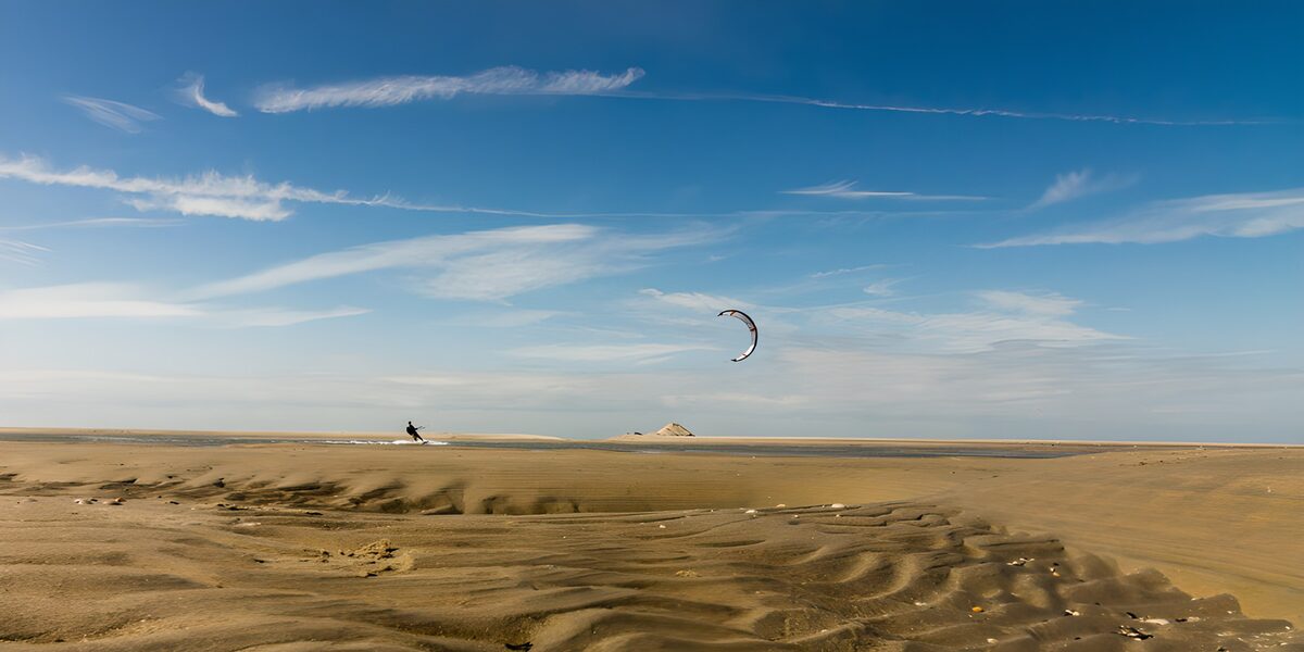 Kitesurfer am weiten Sandstrand