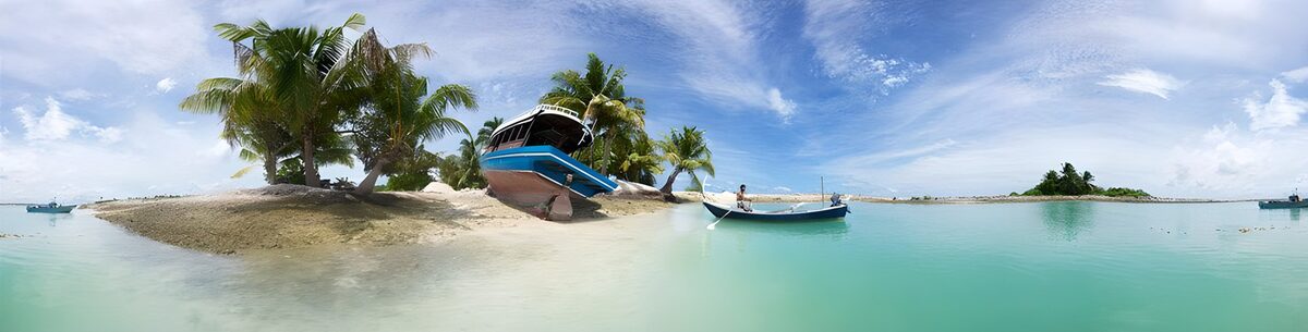 Palmenstrand mit Booten und türkisblauem Meer
