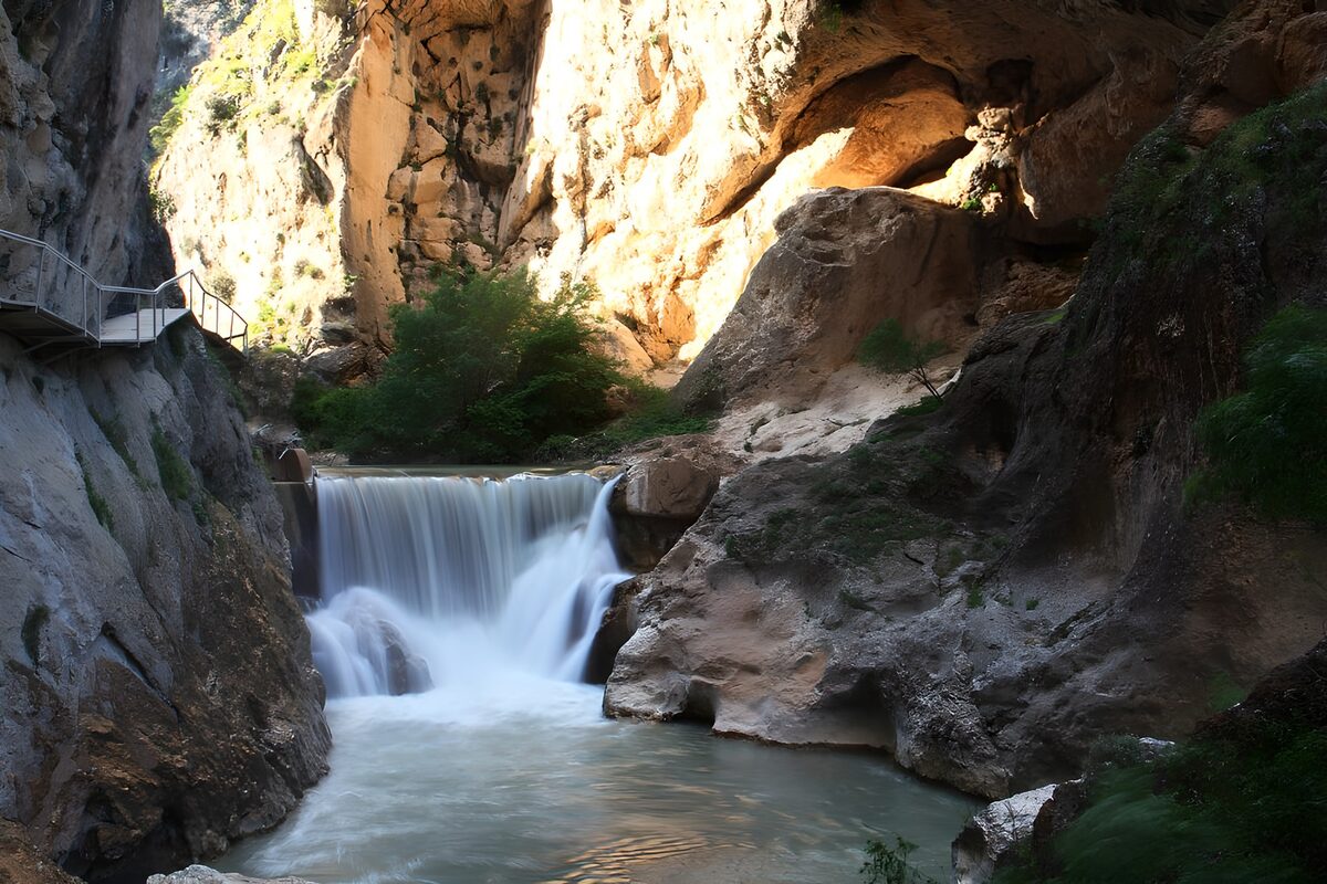 Wasserfall im Schatten hoher Felsen