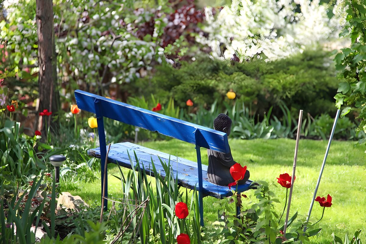 Blaue Holzbank im blühenden Garten