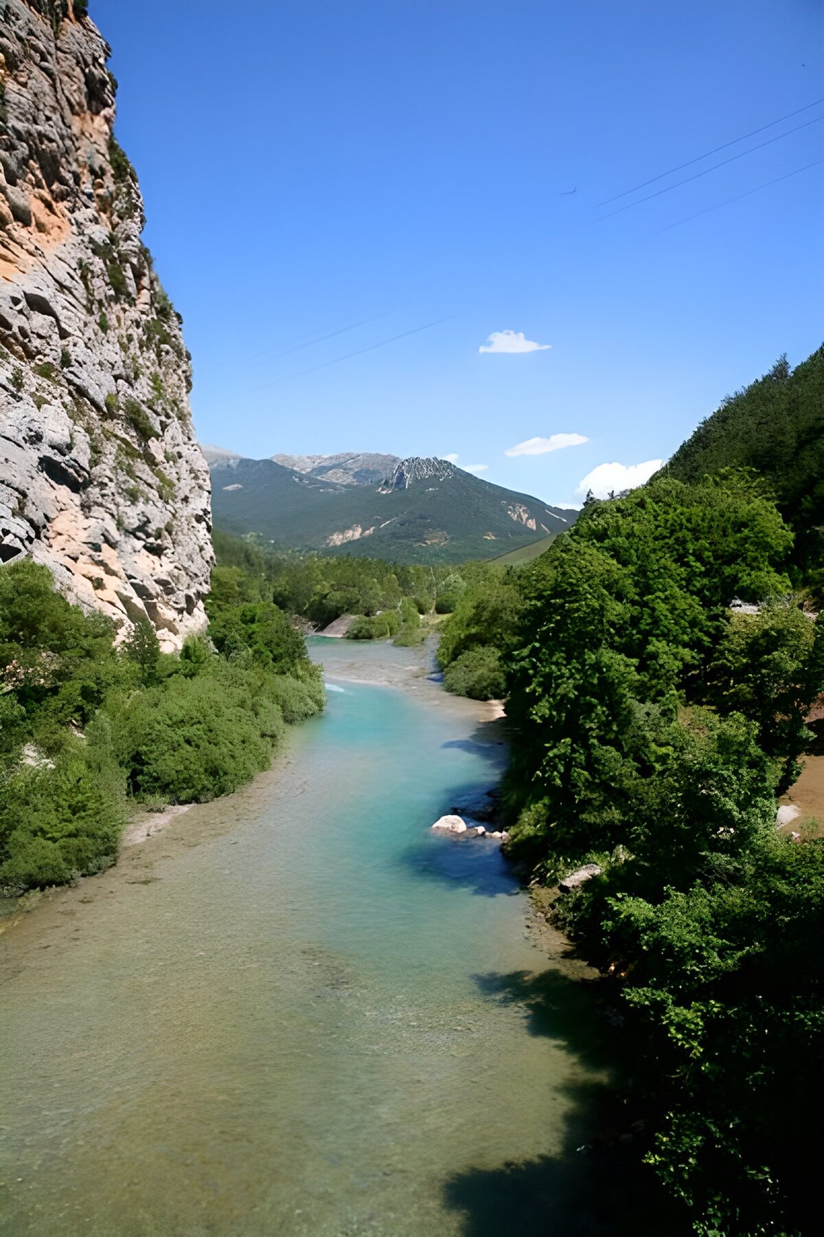 Türkiser Fluss im sonnigen Bergtal