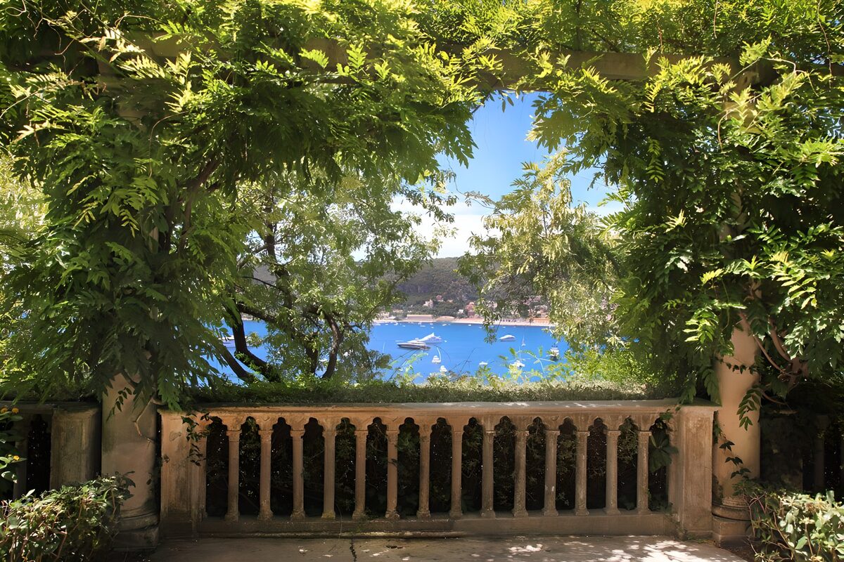 Schattige Terrasse über der blauen Bucht