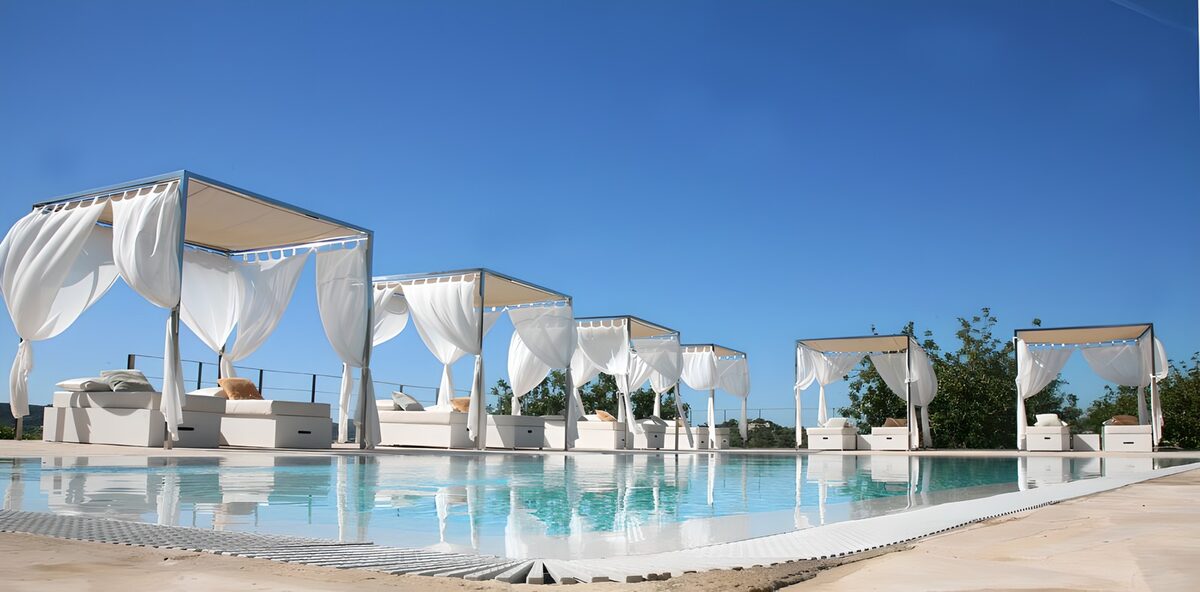 Weiße Himmelbetten am sonnigen Pool