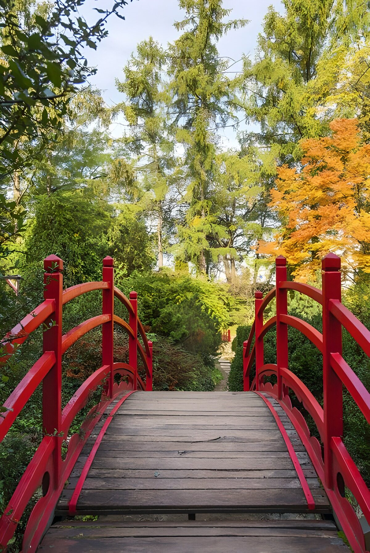 Rote Holzbrücke im stillen Herbstgarten