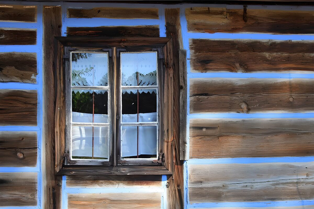 Fenster mit Spitze in brauner Holzfassade