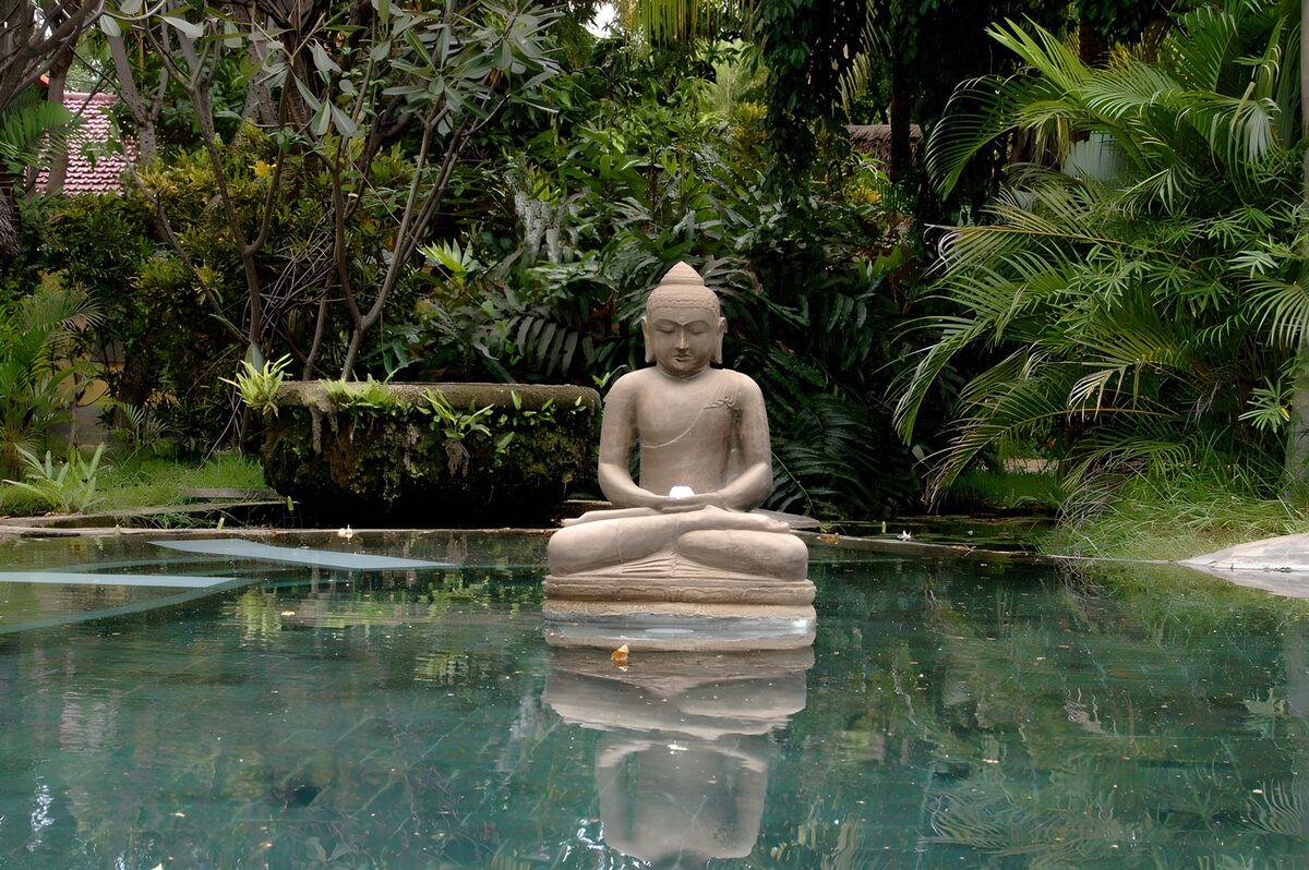 Buddha am Teich im dichten Grün