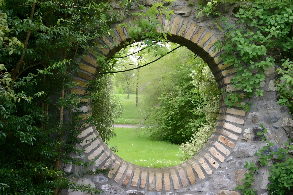 Rundes Mauerfenster ins Gartengrün