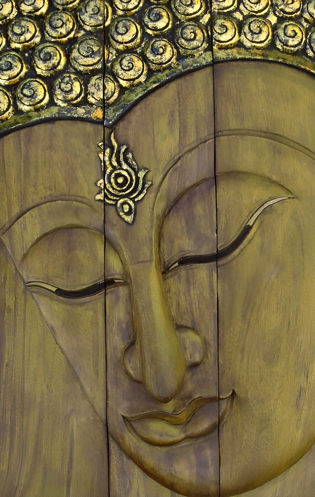 Buddhagesicht als goldbraunes Holzrelief