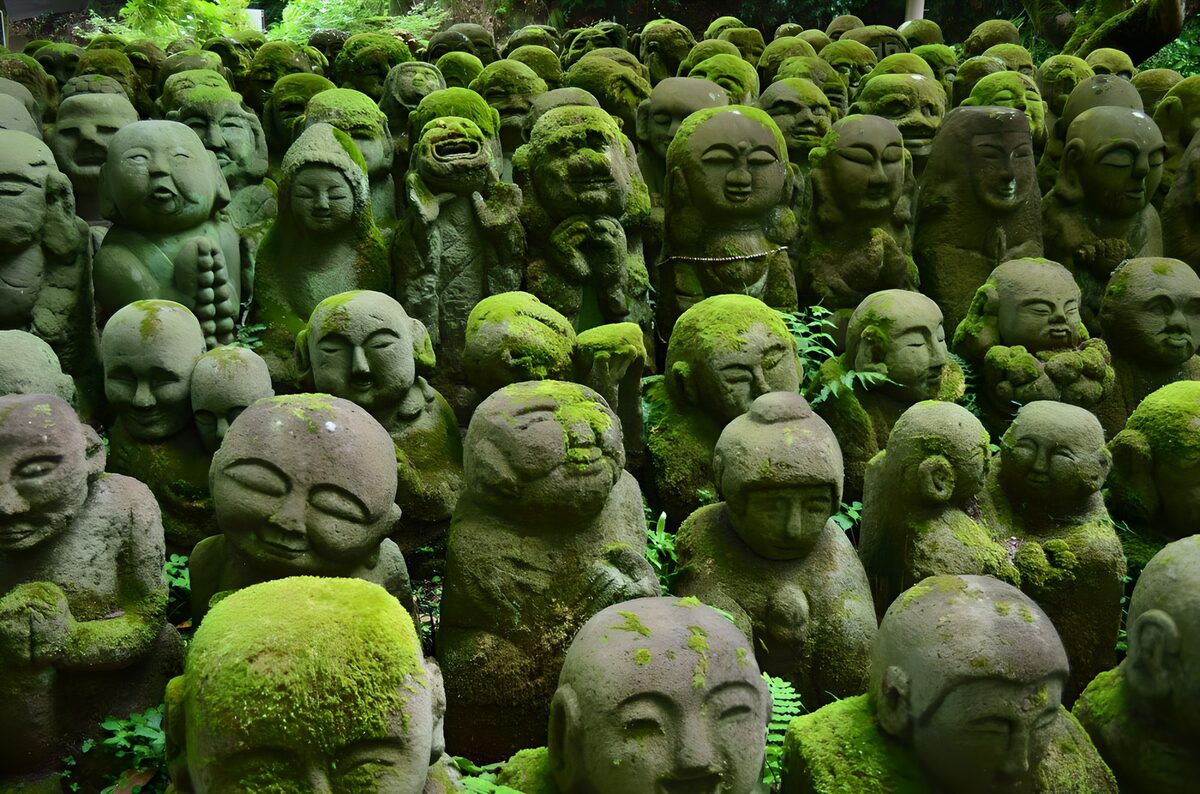 Moosbewachsene buddhistische Steinfiguren