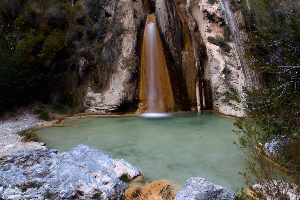 Wasserfall am stillen, hellgrünen Becken