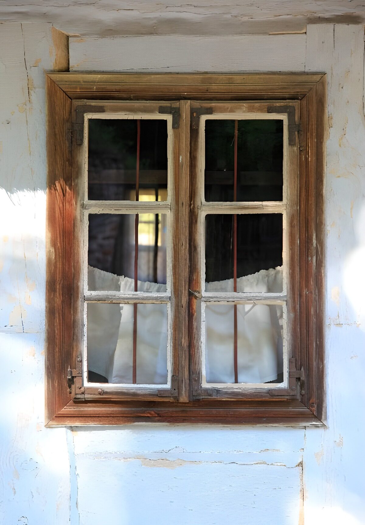 Rustikales Holzfenster mit weißen Gardinen