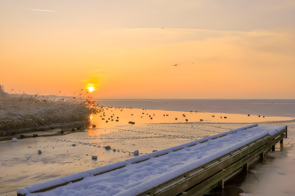 Verschneiter Steg im Sonnenuntergang