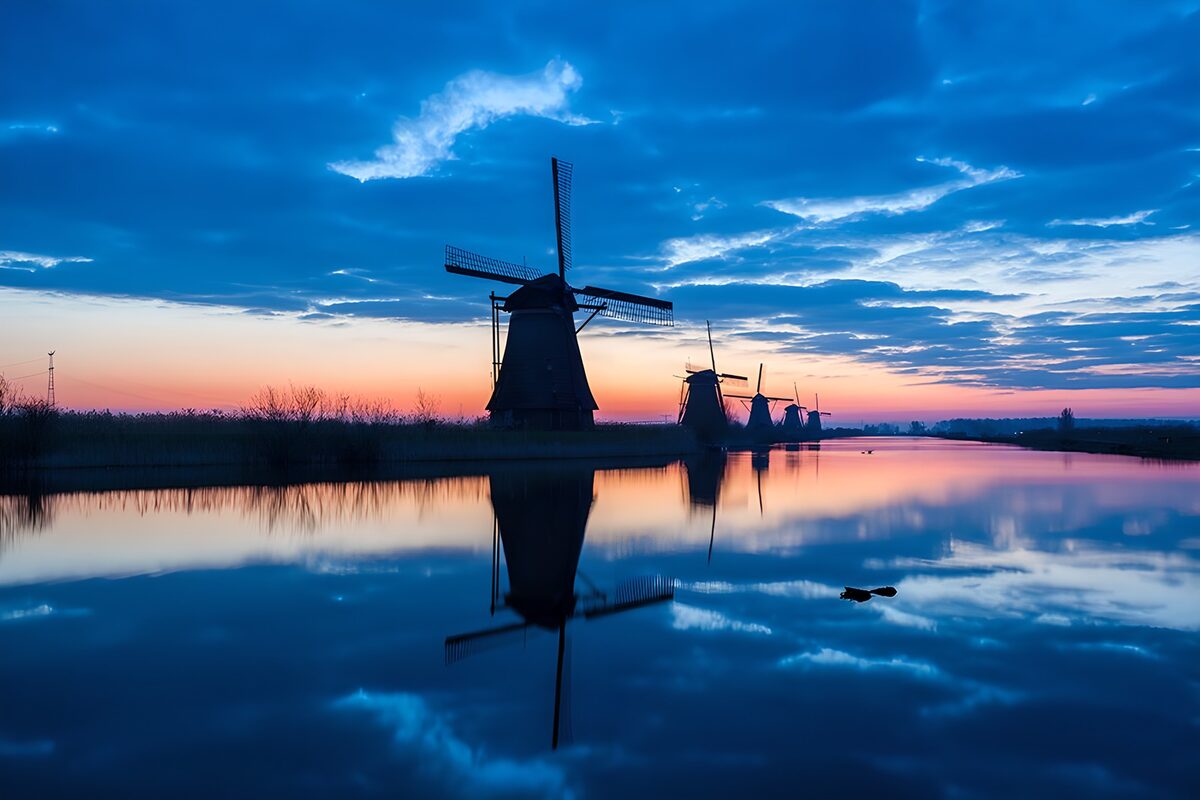 Windmühlen am Wasser in der Abenddämmerung