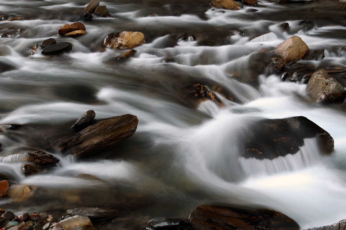 Seidiges Bachwasser zwischen dunklen Felsen