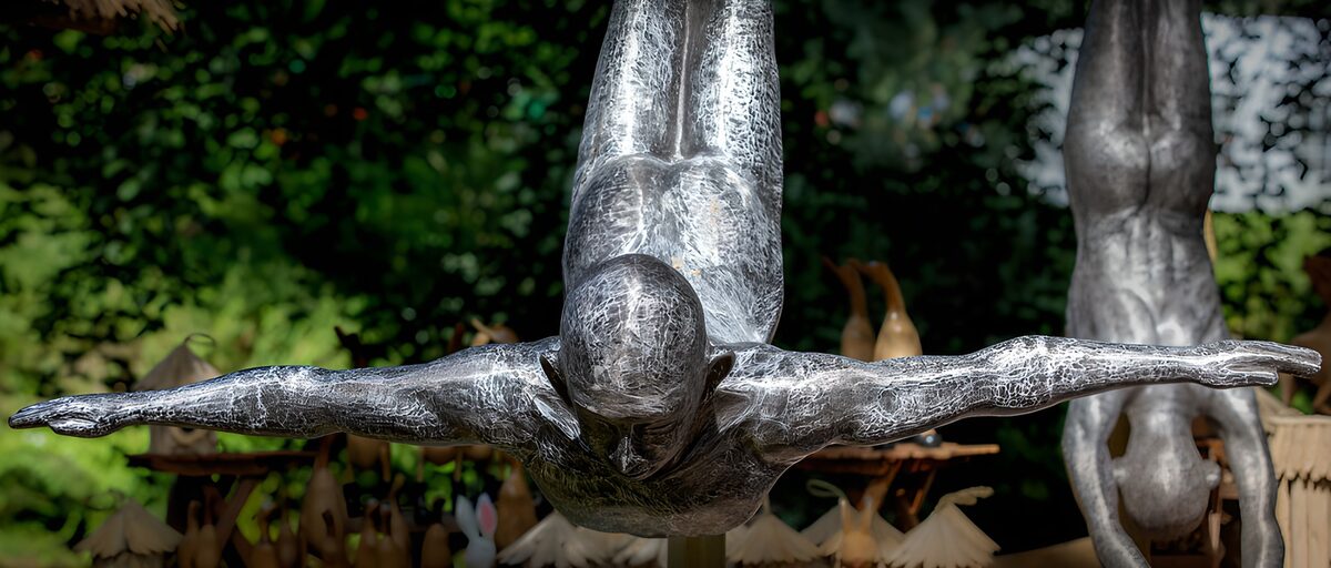 Metallfigur im stillen Kopfsprung