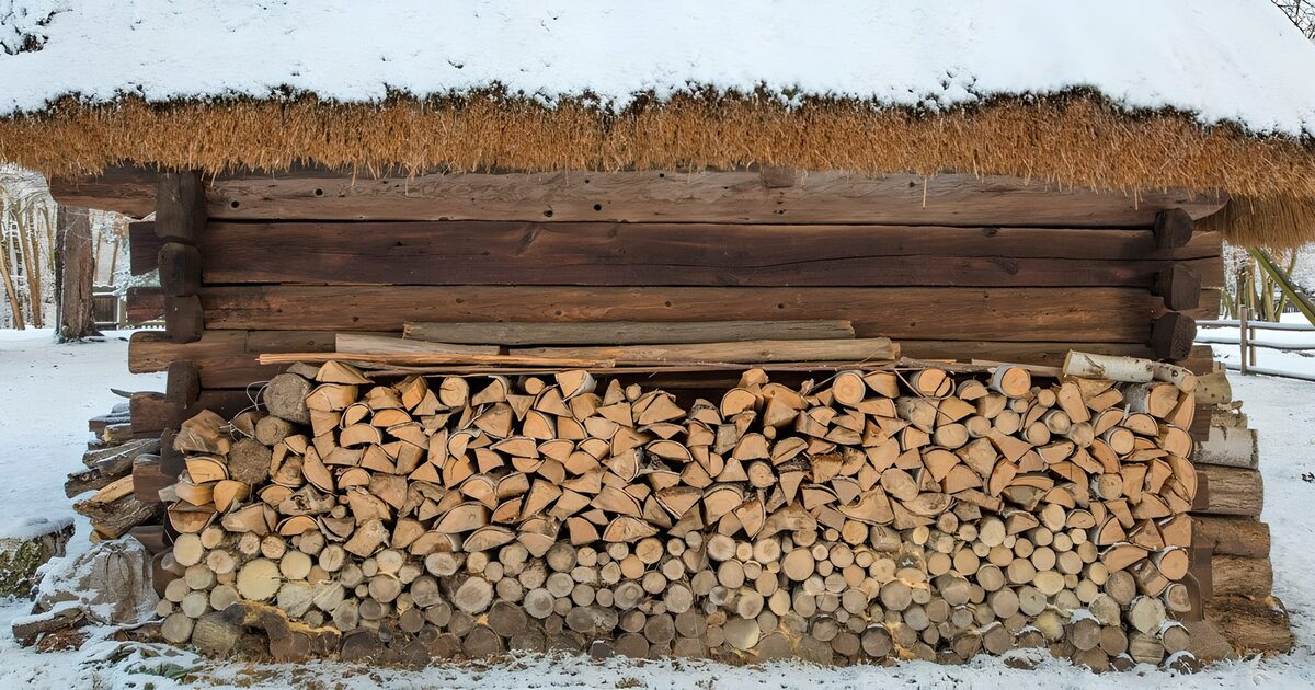 Brennholz unterm verschneiten Strohdach