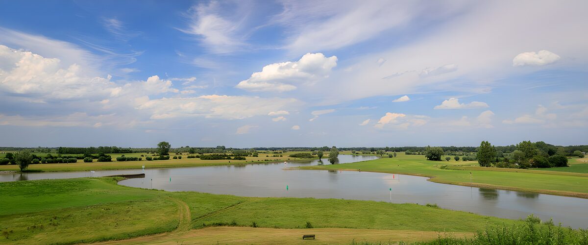 Golfplatz am Wasser unter blauem Himmel