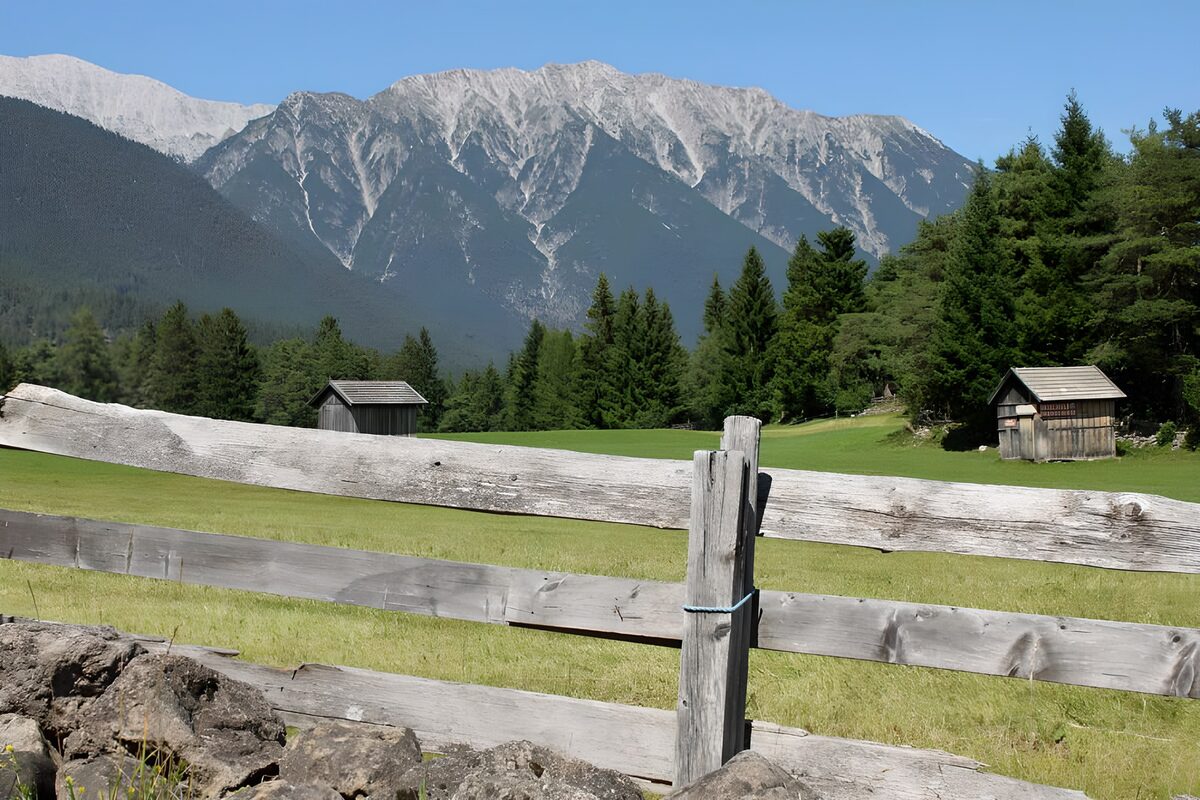 Bergwiese mit Holzschuppen und Zaun
