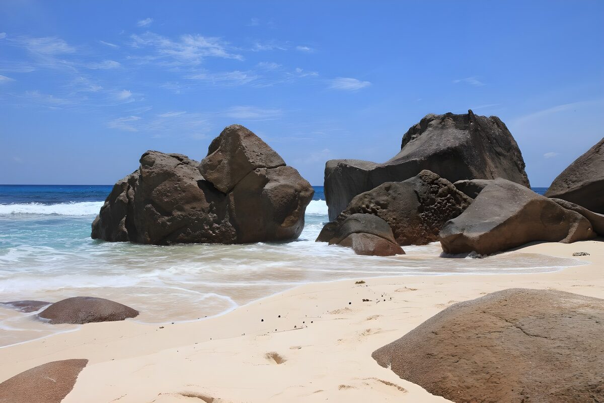 Sonniger Sandstrand mit großen Felsen