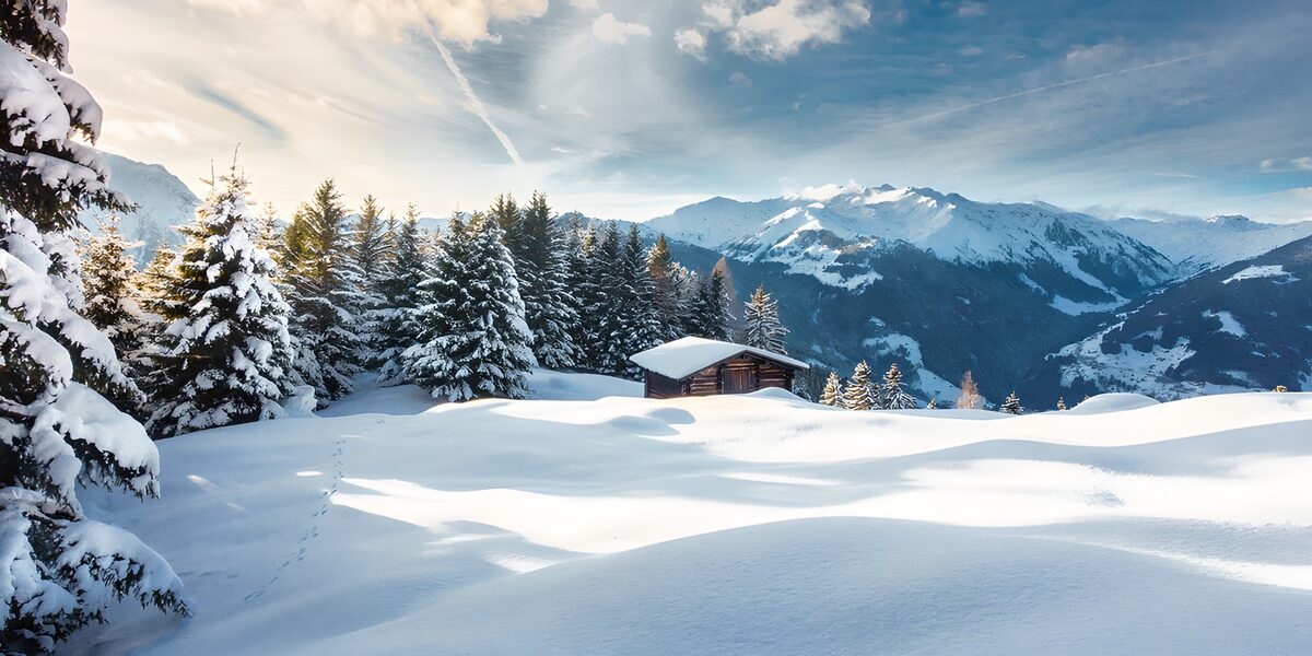 Holzhütte im tief verschneiten Bergwald