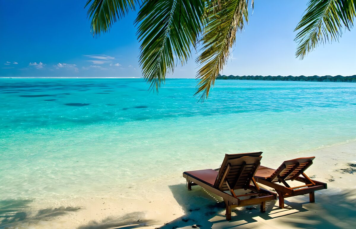 Zwei Strandliegen am türkisblauen Meer