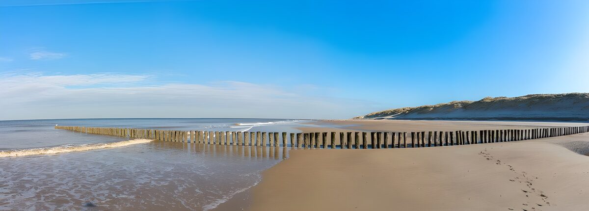 Sandstrand mit Holzpfählen in der Sonne