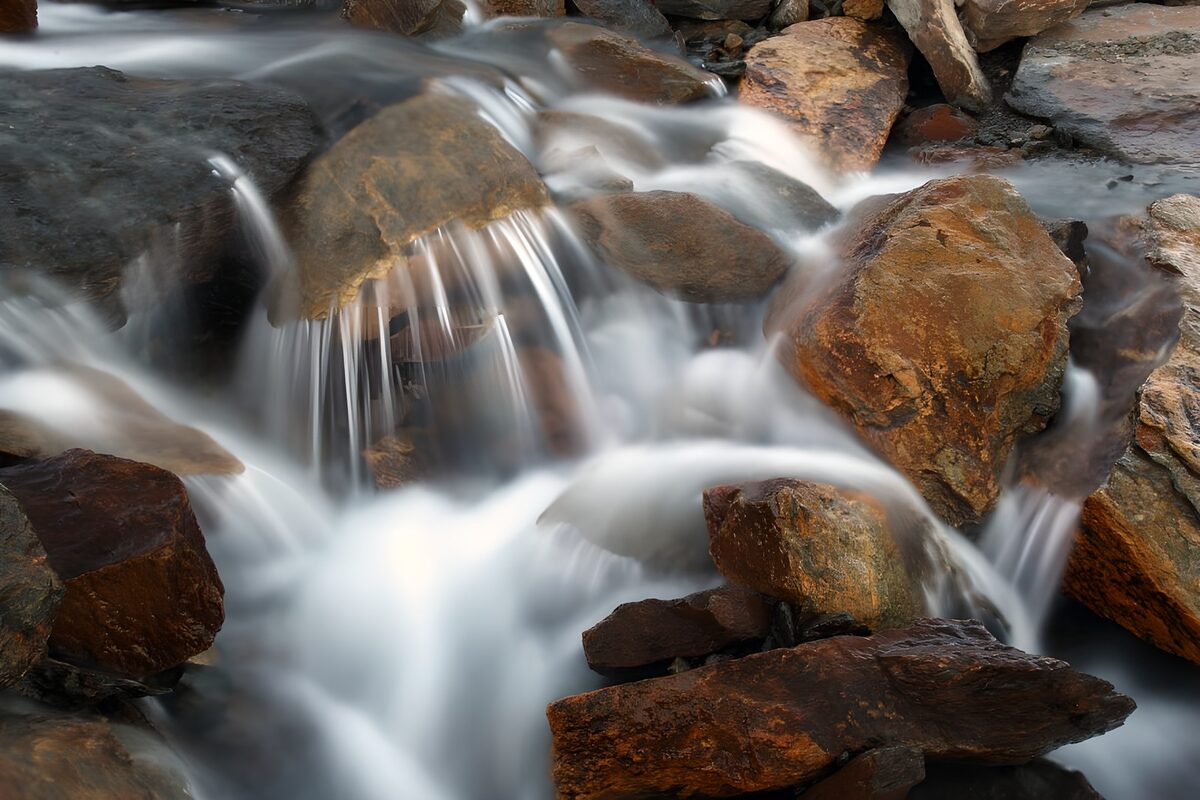 Seidiges Bachwasser zwischen rauen Felsen