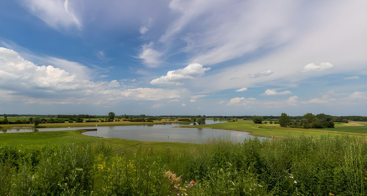 Teich im Grünen unter weitem Himmel