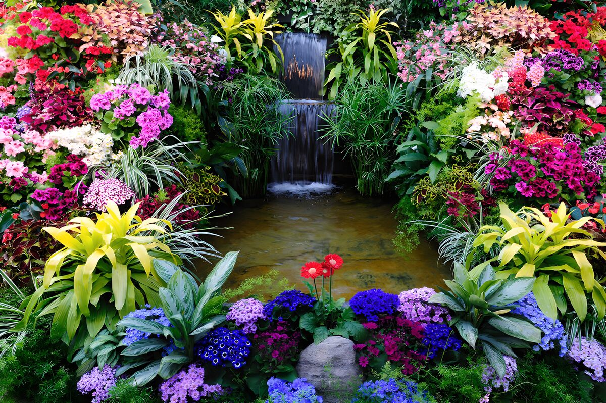 Blütenreicher Garten mit kleinem Wasserfall