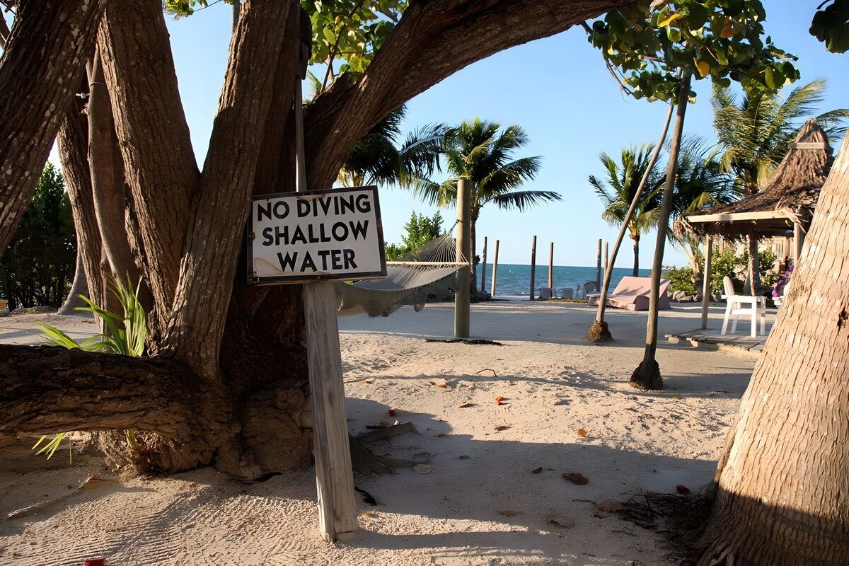 Tropenstrand mit Hängematte und Warnschild
