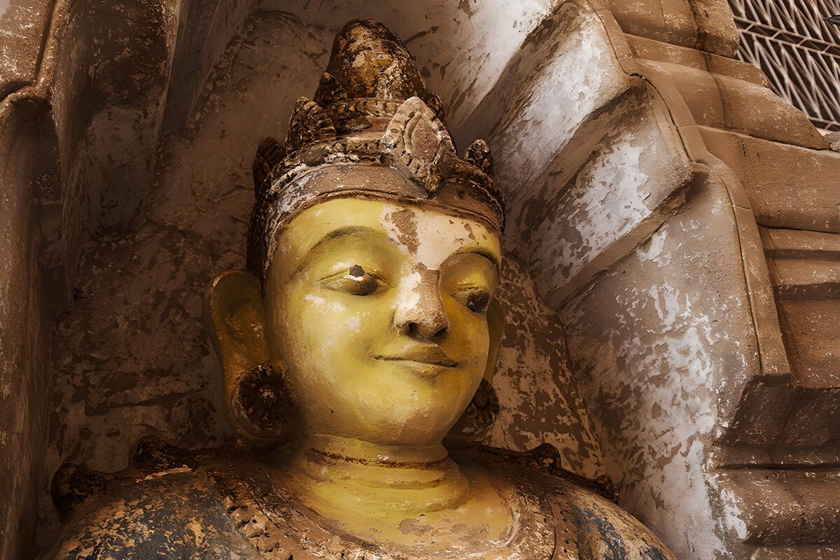 Goldener Buddha in verwitterter Nische