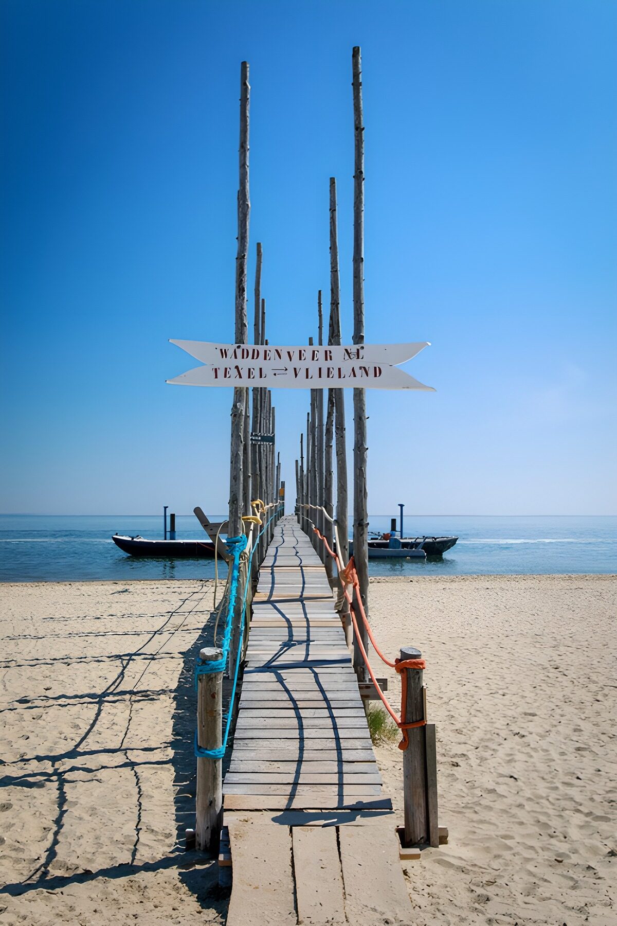 Holzsteg am Strand unter blauem Himmel