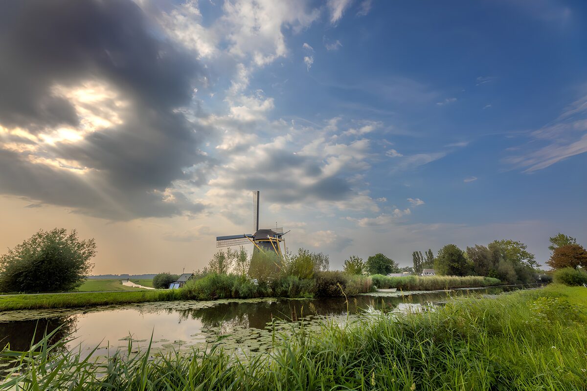 Windmühle am Wasser im Abendlicht