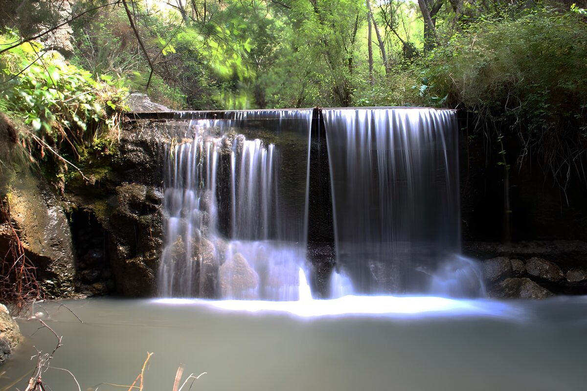 Kleiner Wasserfall am stillen Waldbecken