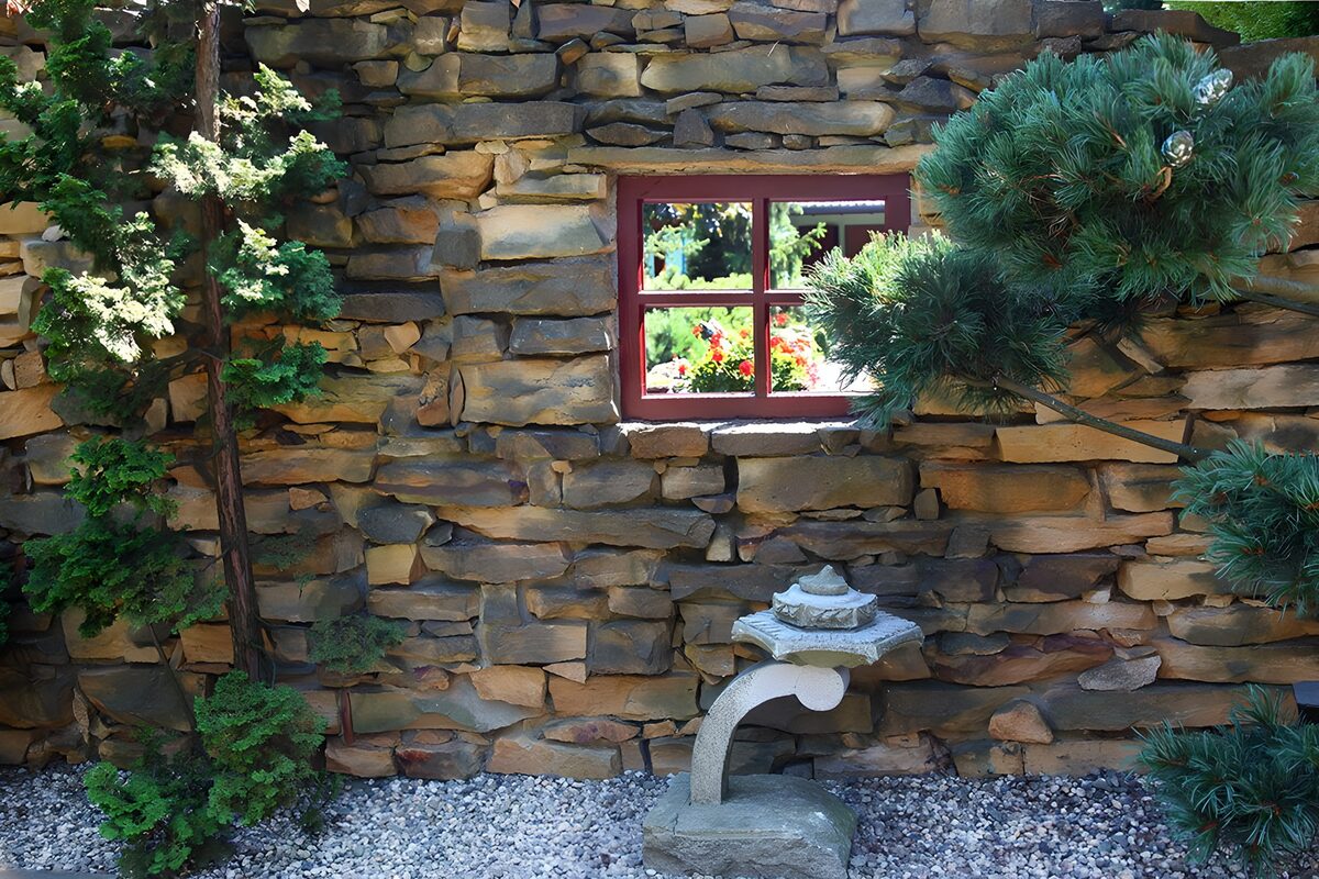 Rotes Fenster in rustikaler Steinmauer