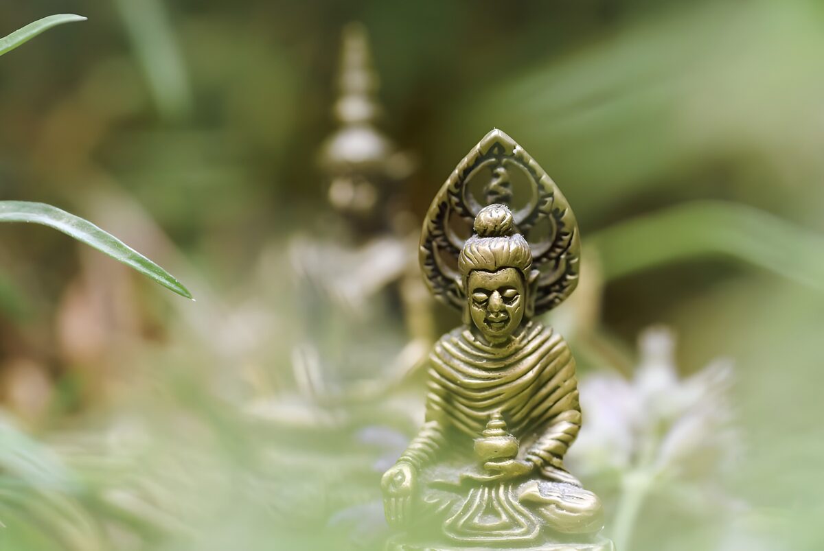 Goldener Buddha im grünen Blätterrahmen